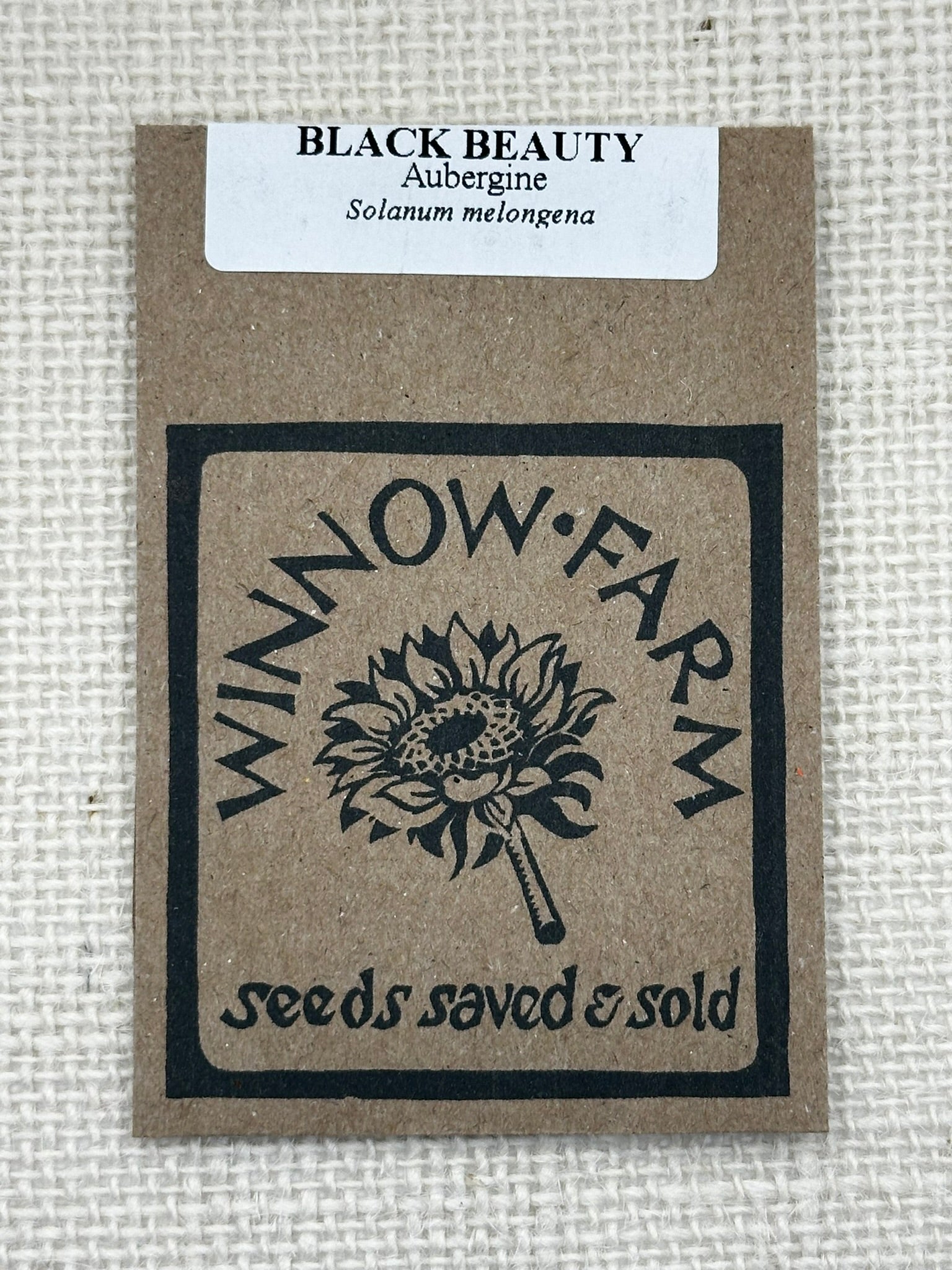 Seed packet from Winnow Farm with black beauty aubergine branding on a beige background