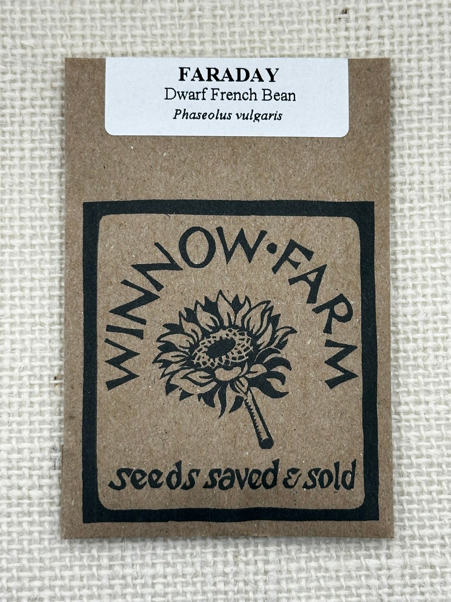 Seed packet for Faraday Dwarf French Bean with Winnow Farm logo on a textured beige background