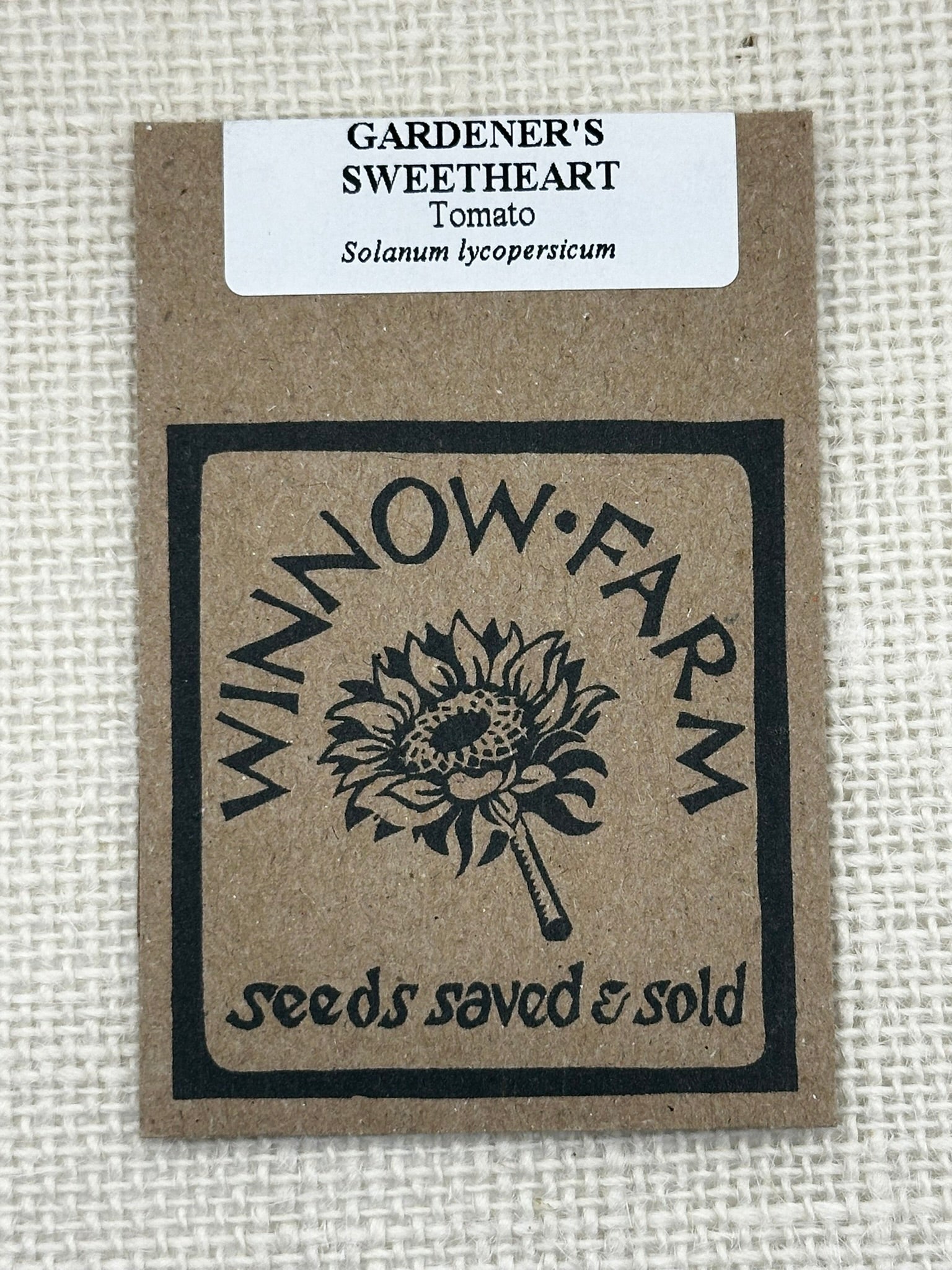 Seed packet for 'Gardener's Sweetheart' tomato from Winnow Farm on a textured beige background.