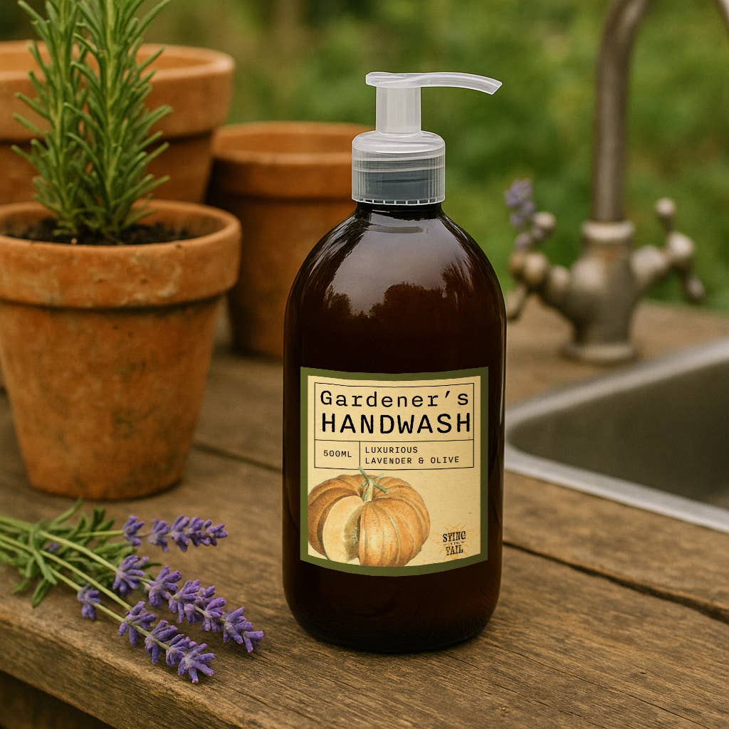 Bottle of Gardener's Handwash on a wooden surface with potted plants and lavender.